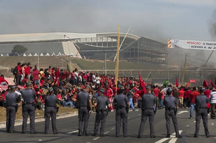 15.mai.2014 - Itaquerão ao fundo, manifestantes e polícia; sem-teto protestam contra a Copa do Mundo e pedem moradia
