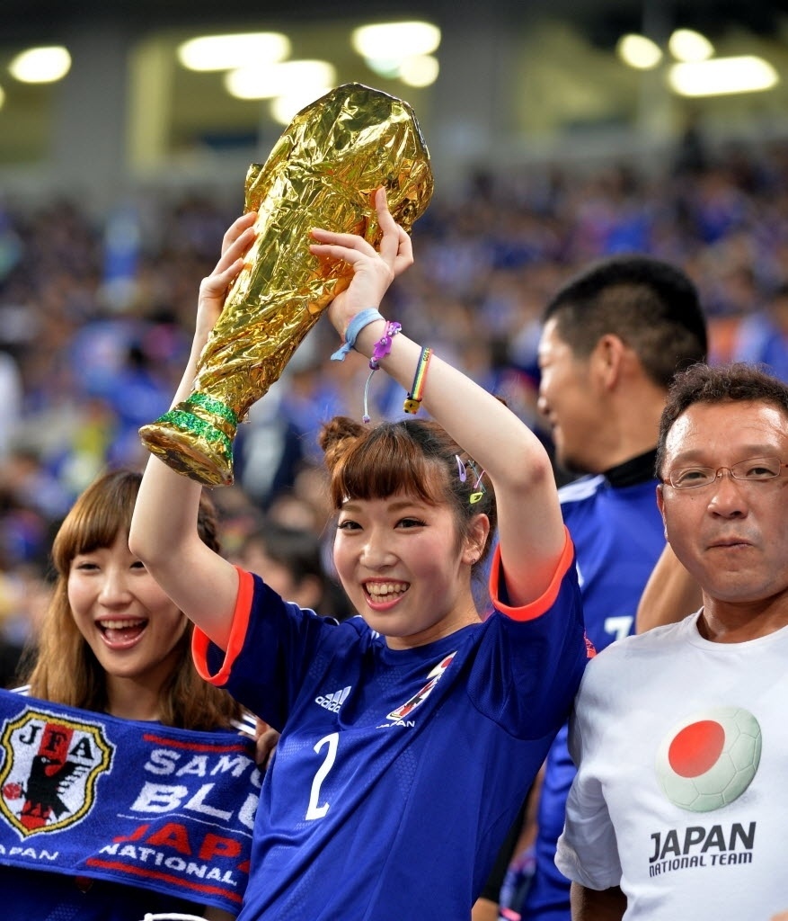 27.mai.2014 - Torcedora levanta réplica da Taça do Mundo em amistoso entre Japão e Chipre, realizado em Saitama