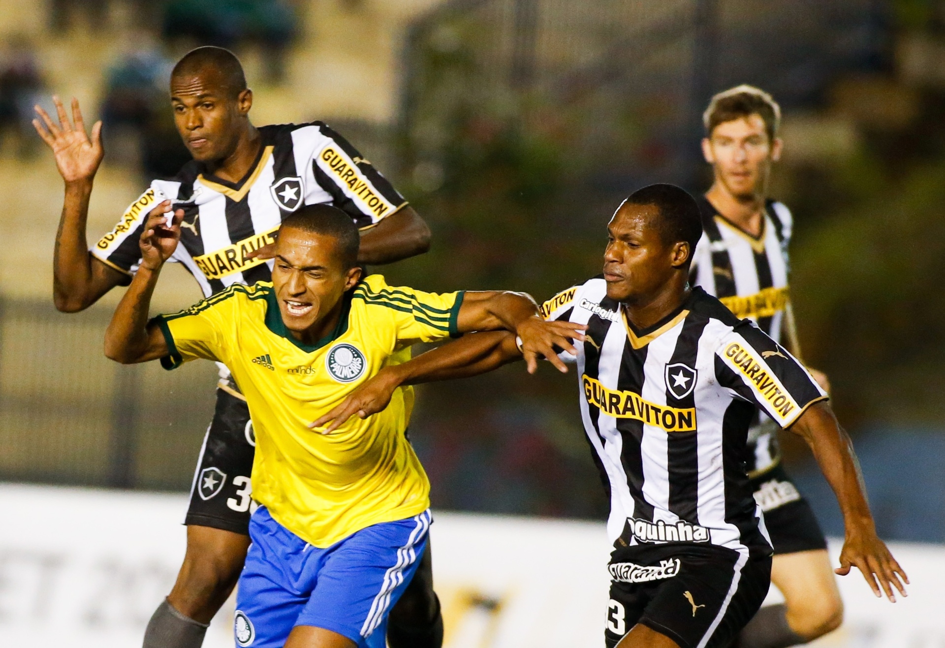 Renato, do Palmeiras, tenta se livrar do marcador do Botafogo em jogo pelo Brasileirão - Alexandre Schneider/Getty Images