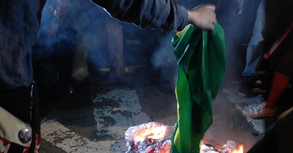 Manifestantes queimam bandeira do Brasil em frente a sede da Federação Paulista de Futebol durante protesto contra a Copa do Mundo realizado em 31 de maio de 2014