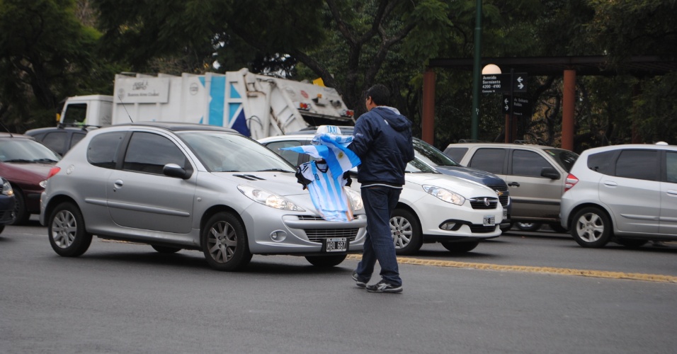 Vendedor ambulante oferece bandeiras e camisas número 10 da seleção argentina nos semáforos da avenida Libertador, em Buenos Aires