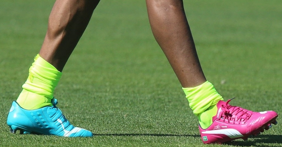 05.jun.2014 - Dante usa uma chuteira de cada cor durante treino da seleção brasileira. O par azul e rosa é faz parte de campanha de uma marca de materiais esportivos