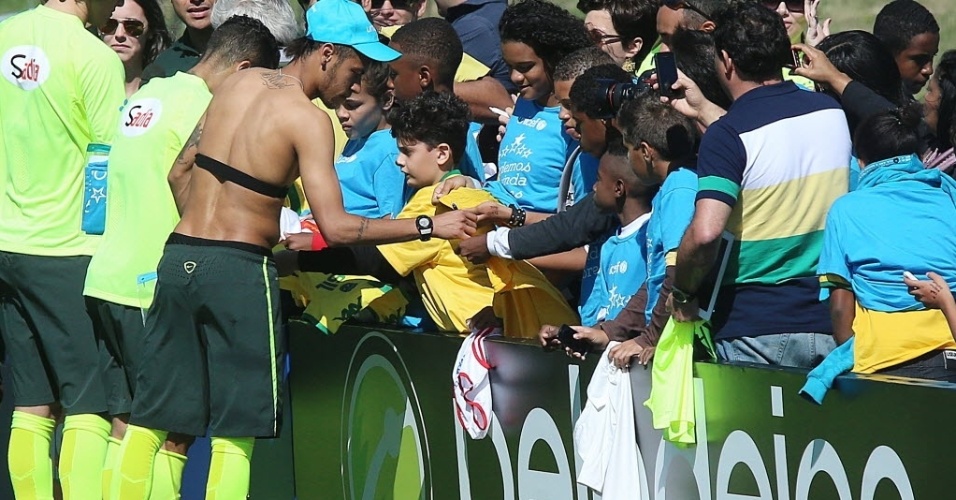 05.jun.2014 - Neymar entrega a sua camisa a garoto que assistia ao treino da seleção brasileira na Granja Comary, a última atividade dos jogadores em Teresópolis antes de viajarem para São Paulo para o amistoso contra a Sérvia