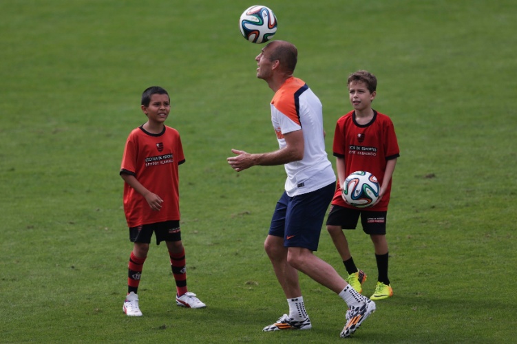 Observado por duas crianças, Arjen Robben, da Holanda brinca com bola após sessão de treinos no CT da Gávea