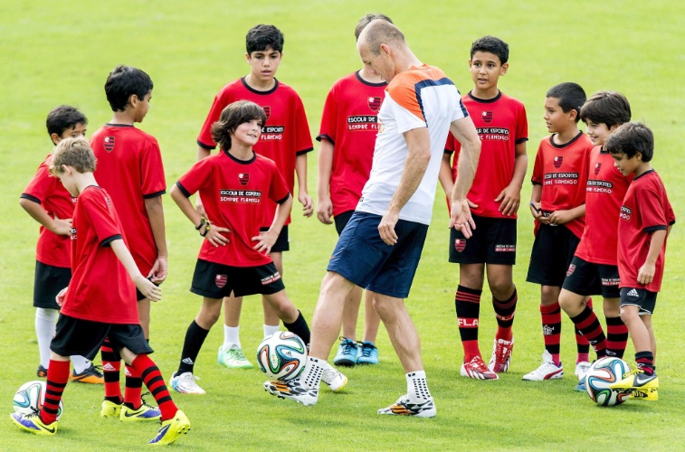 Cercado por diversas crianças, Arjen Robben, da Holanda faz demonstração de habilidade após fim de sessão de treinos no CT da Gávea