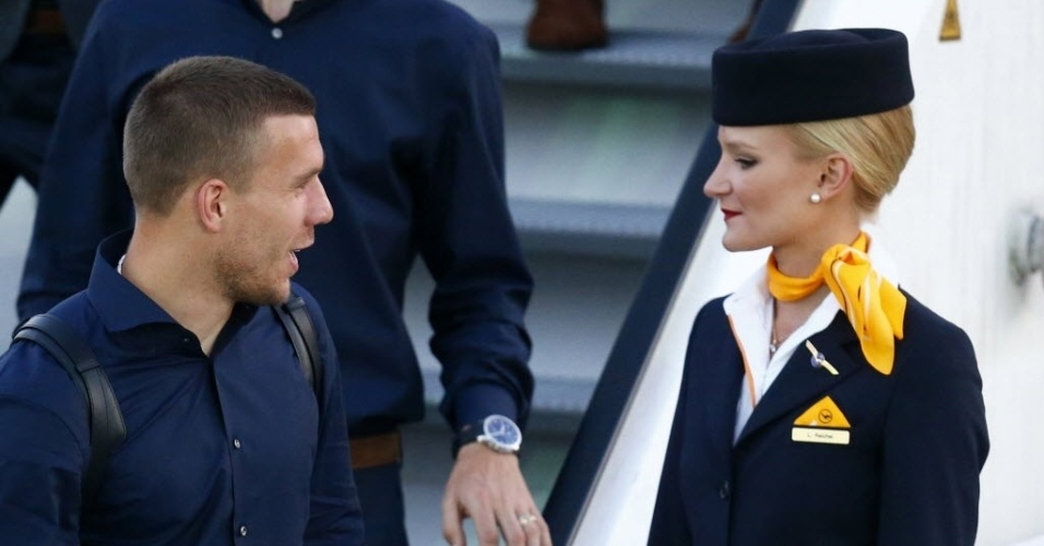 Lukas Podolski, da seleção alemã, sorri para comissária de bordo antes da decolagem do vôo para o Brasil