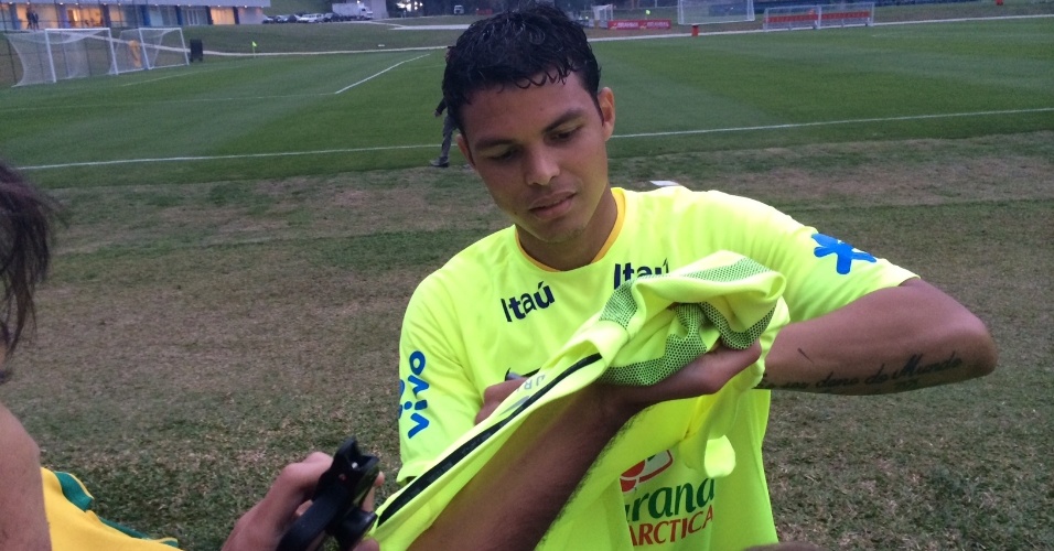 09.jun.2014 - Zagueiro Thiago Silva autografa camisa de torcedor após treino da seleção
