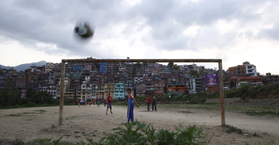 Crianças jogam bola em um campinho improvisado na favela em Kirtipur, no Nepal