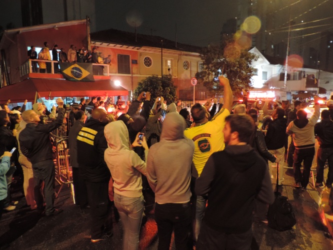 10.jun.2014 - Mesmo longe do ônibus, torcedores tentam registrar chegada da seleção brasileira a hotel em São Paulo
