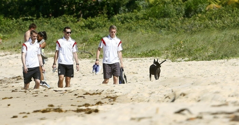 10.jun.2014 - Neuer, Klose e Durm caminham descalços tranquilamente em uma praia próxima a Porto Seguro, na Bahia