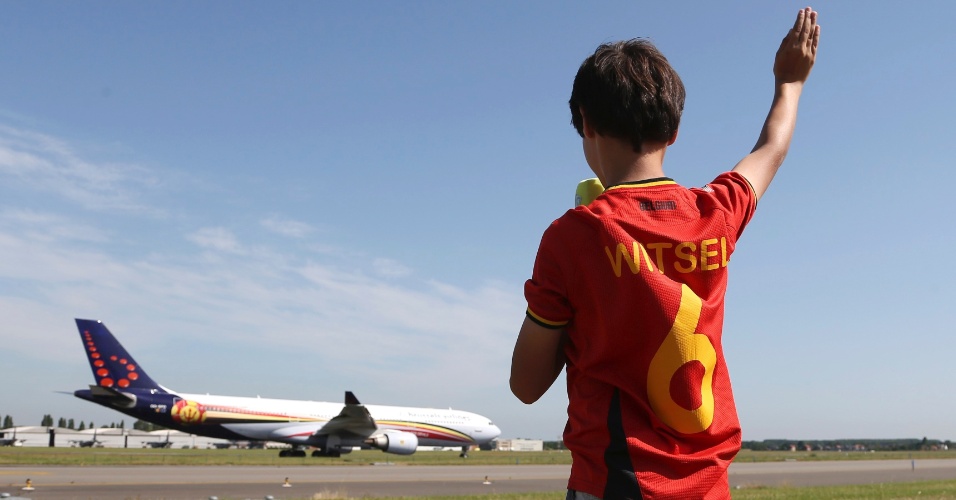 10.jun.2014 - Garoto acena para aeronave que leva seleção da Bélgica, que parte para o Brasil