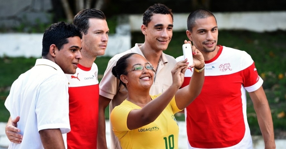 Torcedores brasileiros tiram 'selfie' com Lichtsteiner e Inler, jogadores da Suíça, em Porto Seguro-BA