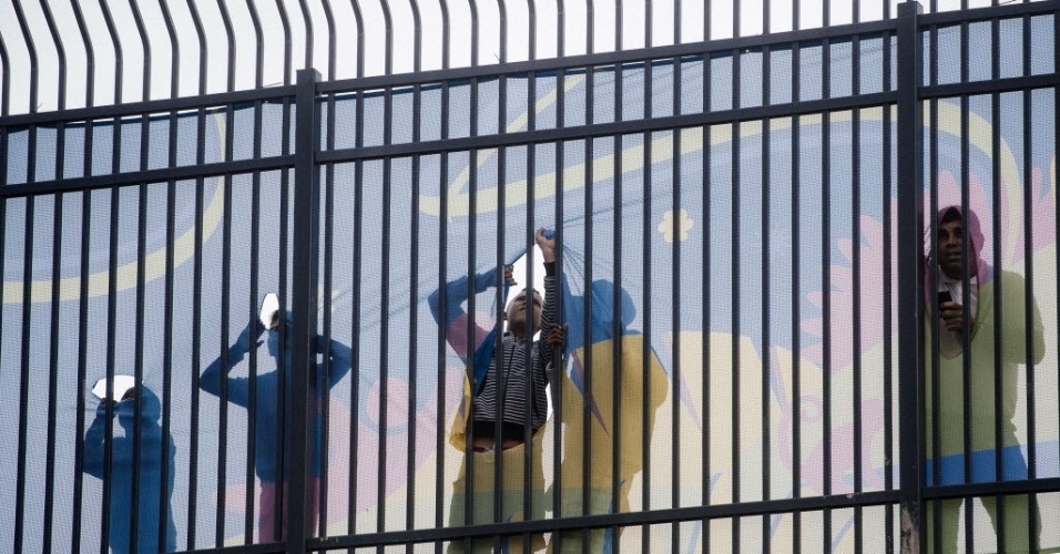 11. jun. 2014 - Torcedores do Brasil tentam espiar dentro do Itaquerão antes de treino da seleção brasileira