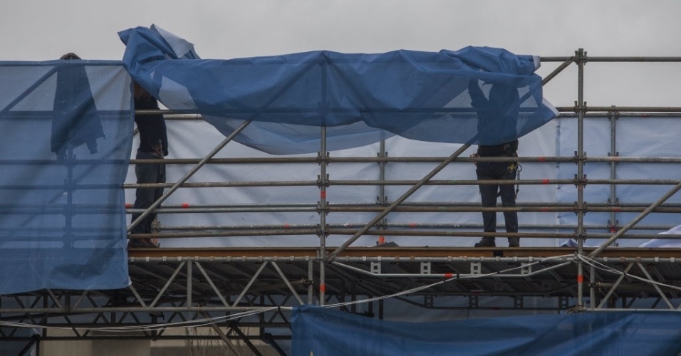 11. jun. 2014 - Trabalhadores instalam lona para cobrir a estrutura metálica do Itaquerão para a abertura da Copa do Mundo