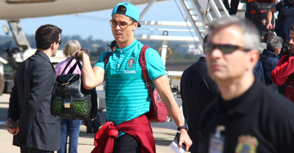 11.jun.2014 - De óculos escuros e boné, Cristiano Ronaldo desce do avião na chegada da delegação portuguesa ao aeroporto de Campinas