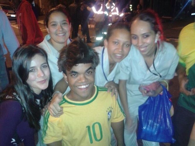 11.jun.2014 - Marquinhos Anão, da Record, posa para fotos ao lado de torcedores em frente ao hotel da seleção em São Paulo