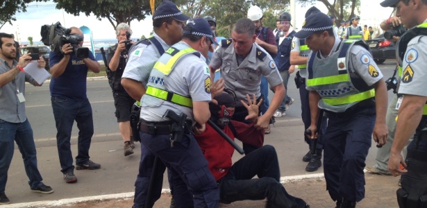 12.jun.2014 - Manifestante mascarado é detido ao tentar se aproximar com protesto de Fan Fest no DF