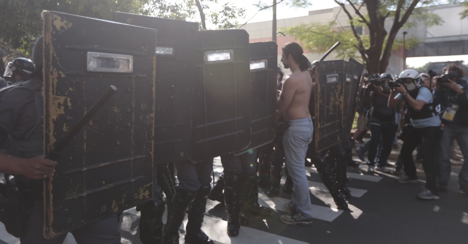 12.jun.2014 - Manifestante tenta passar por barreira de policiais na Radial Leste