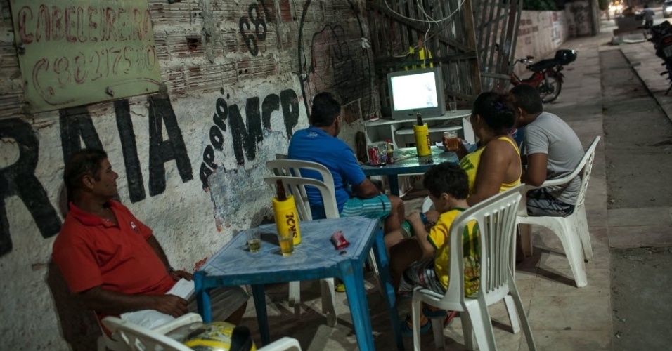 12.jun.2014 - Moradores da Comunidade Raiz da Praia, em Fortaleza, improvisam para assistir à estreia do Brasil na Copa
