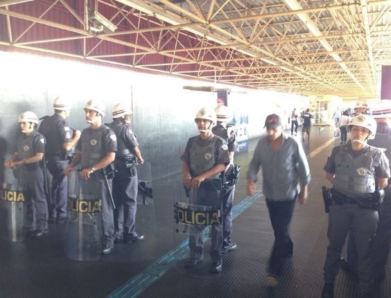 12.jun.2014 - Policiais militares fazem a segurança de torcedores que chegam à estação Itaquera
