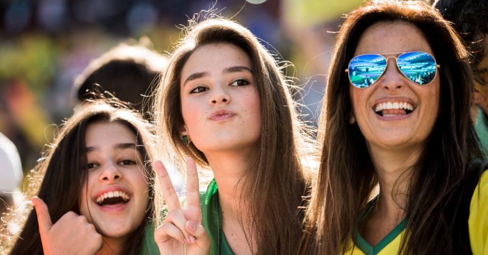 12.jun.2014 - Trio de torcedoras posa para foto na arquibancada do Itaquerão, antes de Brasil x Croácia