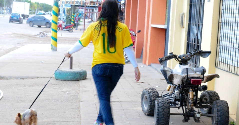 Moradora do Chuí se apressa com seu cachorrinho para não perder o início do jogo do Brasil contra a Croácia