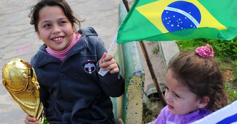 Meninas se divertem com bandeiras de Brasil e Uruguai na expectativa da estreia da seleção na Copa