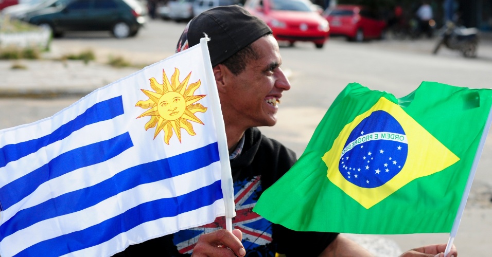 Vendedor ambulante oferece bandeirinhas de Uruguai e Brasil bem na fronteira entre os dois países no Chuí