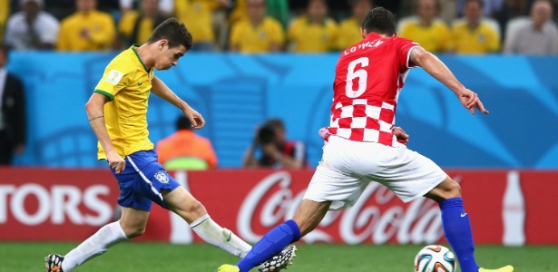 Oscar chuta para marcar o terceiro gol do Brasil na vitória por 3 a 1 sobre a Croácia na estreia da Copa