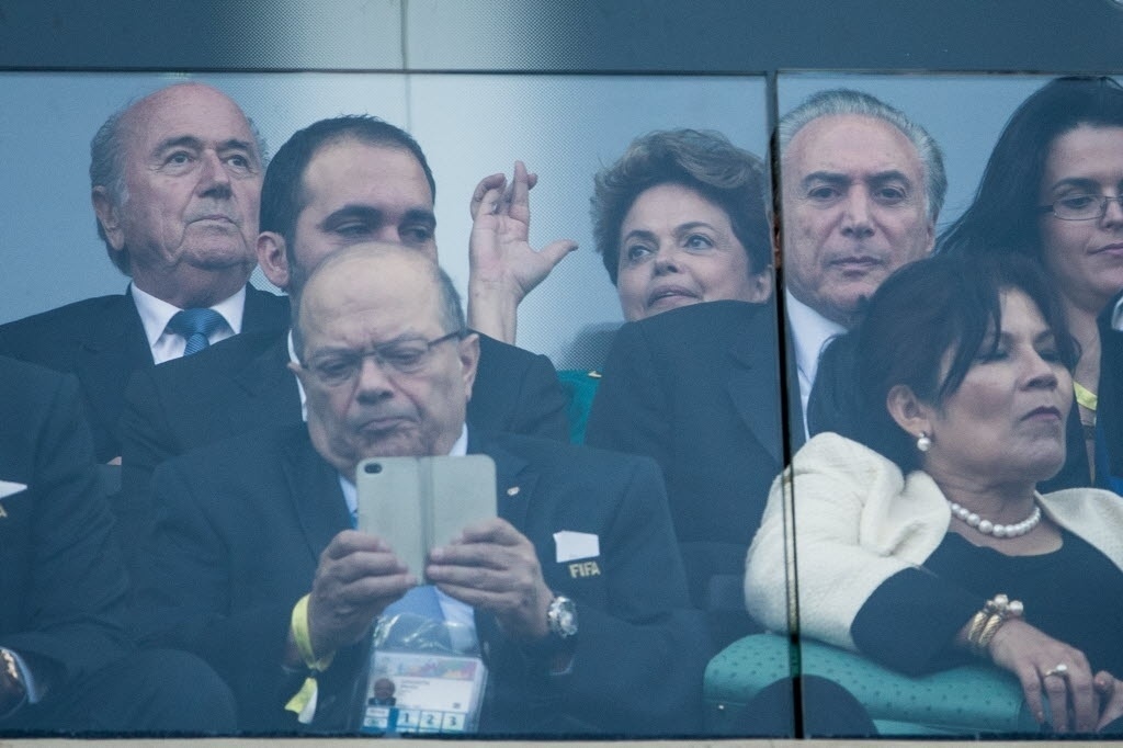 12.jun.2014 - Presidente Dilma Rousseff aguarda início da partida entre Brasil e Croácia e faz sinal de figa no Itaquerão