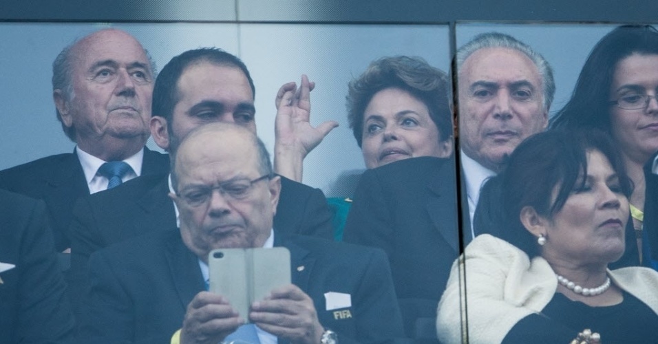 12.jun.2014 - Presidente Dilma Rousseff aguarda início da partida entre Brasil e Croácia e faz sinal de figa no Itaquerão