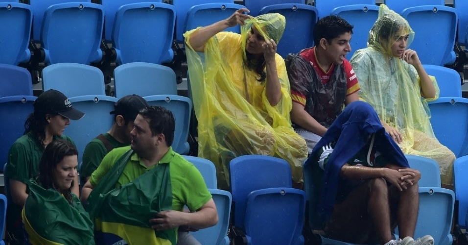13.jun.2014 - Torcedores ficam encharcados por causa da forte chuva na Arena das Dunas, em Natal, antes do jogo entre México e Camarões