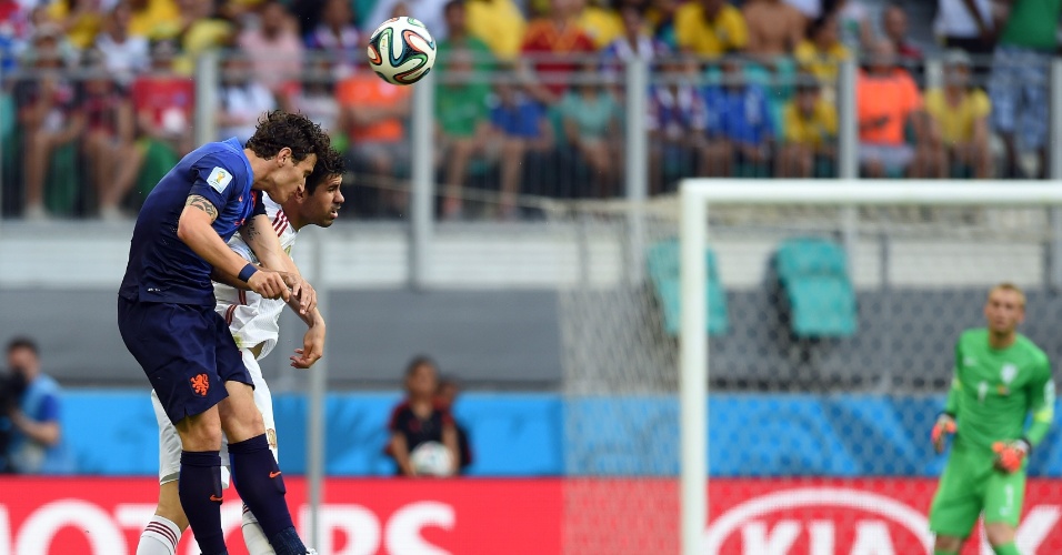13.jun.2014 - Diego Costa e Daryl Janmaat dividem a bola no alto na partida entre Espanha e Holanda, reedição da final de 2010