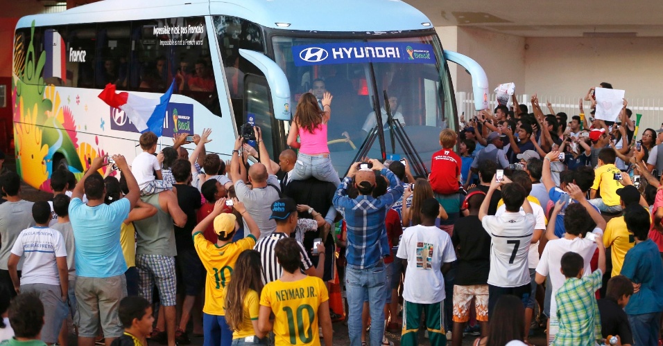 Torcedores tiram fotos do ônibus com a delegação da seleção da França em saída do estádio Santa Cruz, em Ribeirão Preto
