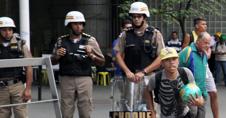 14.jun.2014 - Homem joga bola na frente de policiais durante protesto contra a Copa do Mundo em Belo Horizonte