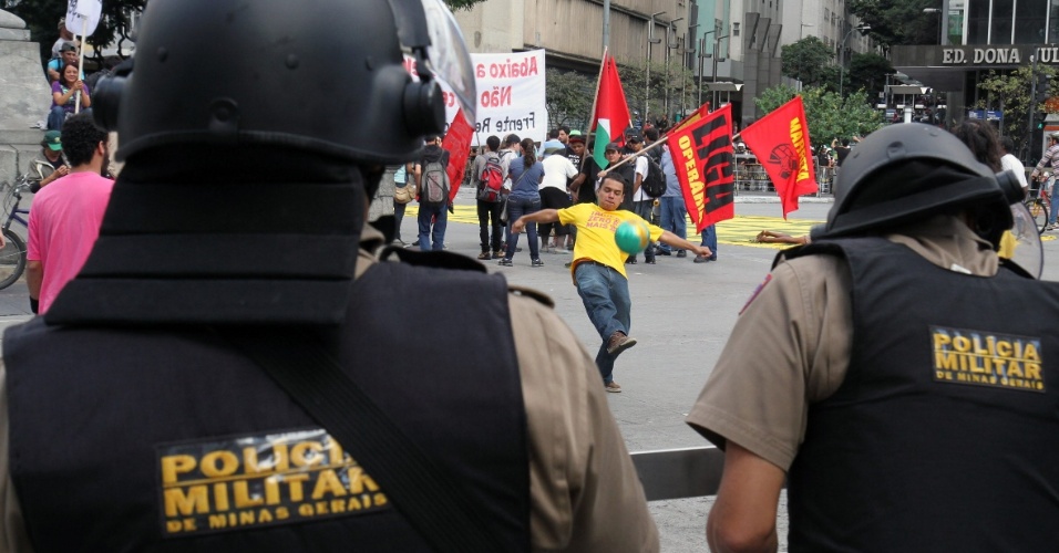 14.jun.2014 - Homem joga bola na frente de policiais durante protesto contra a Copa do Mundo em Belo Horizonte