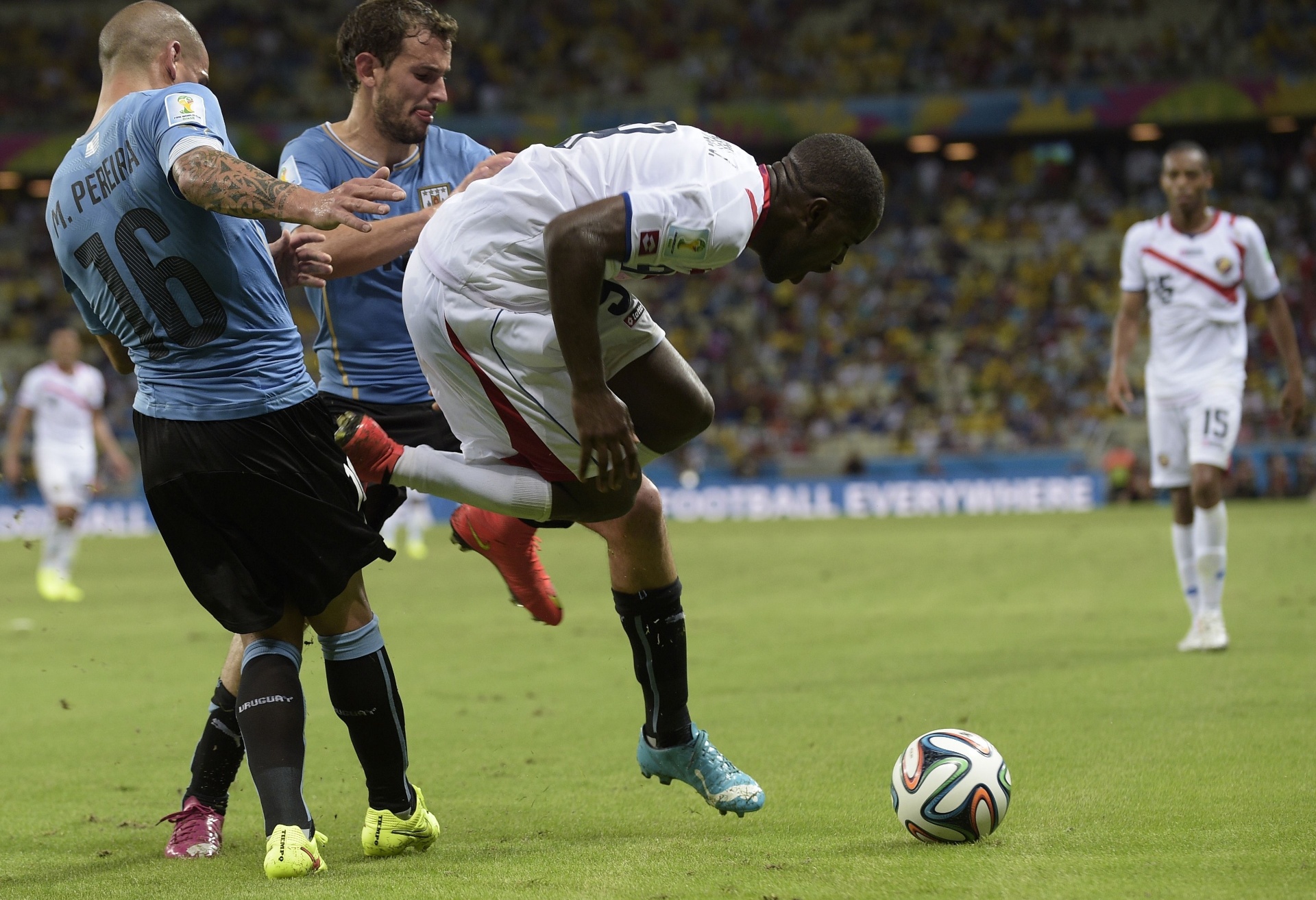 14.jun.2014 - Joel Campbell sofre dura falta de Maxi Pereira durante vitória da Costa Rica sobre o Uruguai