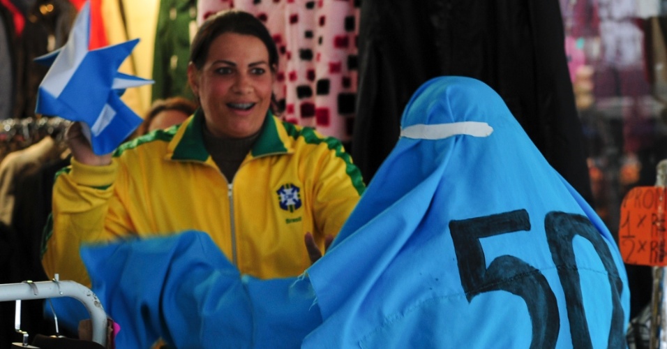 14.jun.2014 - Torcedor fantasiado de Fantasma de 50 brinca com brasileira