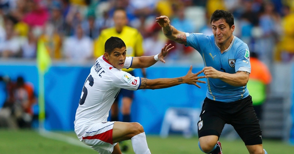 Uruguaio Cristian Rodriguez tenta passar pela marcação de Cristian Gamboa, da Costa Rica, na estreia das seleções na Copa do Mundo
