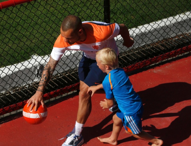 Wesley Sneijder brinca com criança após treino da Holanda, no Rio de Janeiro