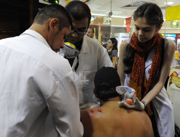 15.06.14 - Homem é atendido após ser ferido nas costas em protesto no Rio de Janeiro