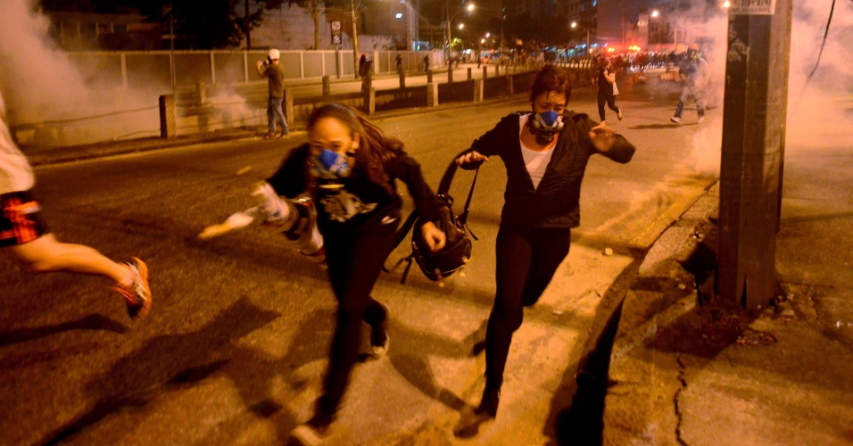 15.06.14 - Manifestantes correm após a polícia lançar gás lacrimogênio na Tijuca