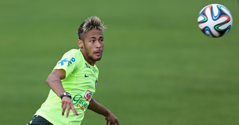 Neymar põe a língua de fora enquanto se concentra para tentar um chute no treino da seleção brasileira