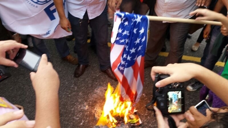 16.06.14 - Manifestantes queimam bandeira dos Estados Unidos em Natal, onde a seleção americana enfrentará Gana às 19h