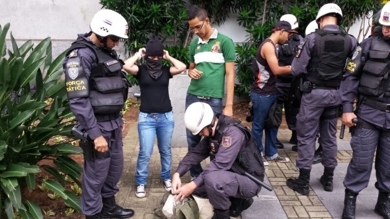 16.06.14 - Manifestante tem mochila revistada pela polícia em protesto em Natal