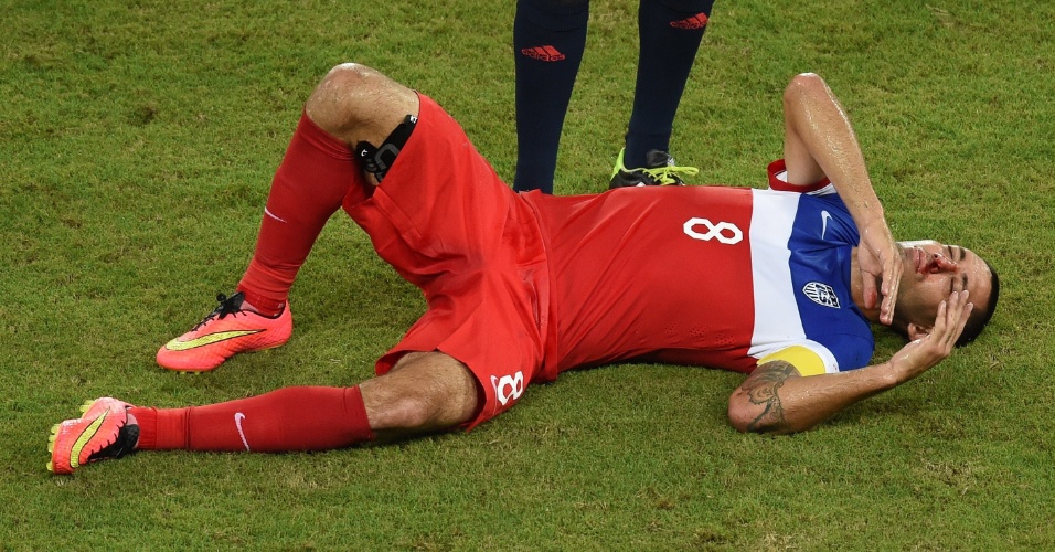 16.jun.2014 - Dempsey fica caído no gramado com o nariz sangrando após dividida com Boye, da seleção de Gana