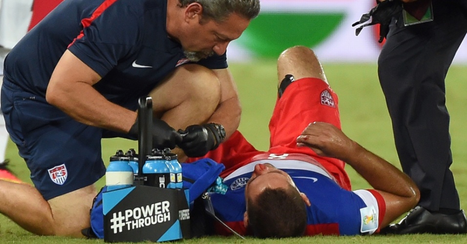 16.jun.2014 - Dempsey recebe atendimento médico depois de dividir a bola e ficar com nariz sangrando