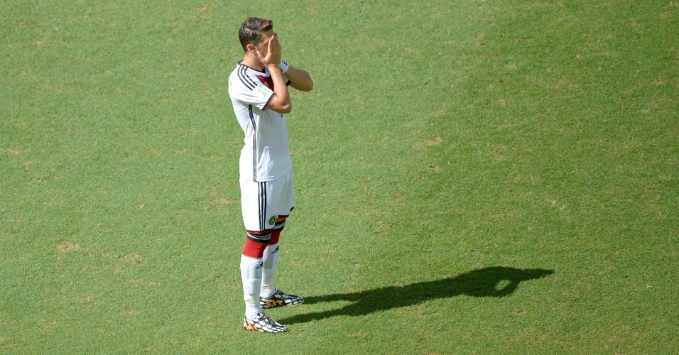 Mesut Ozil coloca a mão no rosto debaixo do sol forte de Salvador, na Arena Fonte Nova, durante jogo entre Alemanha e Portugal