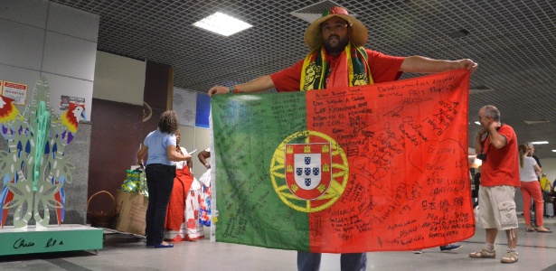 O português José Carlos Marques carrega bandeira de Portugal e colhe autógrafos de famosos e anônimos