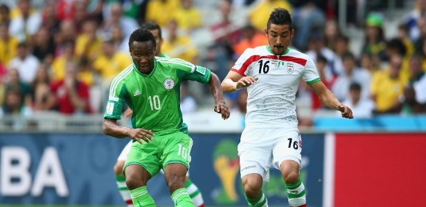 Obi Mikel tenta passe para a Nigéria cercado por jogador iraniano